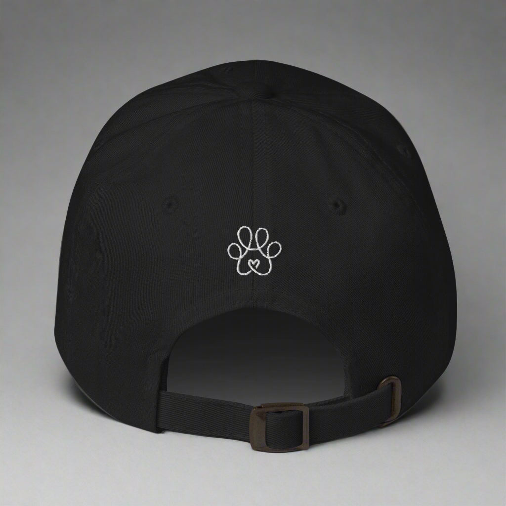 Black cap with a white paw print design on a gray background