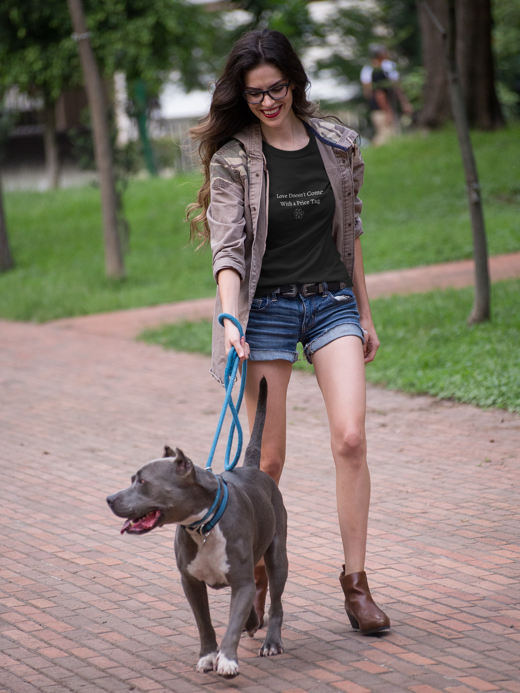 Woman walking a dog on a leash in a park