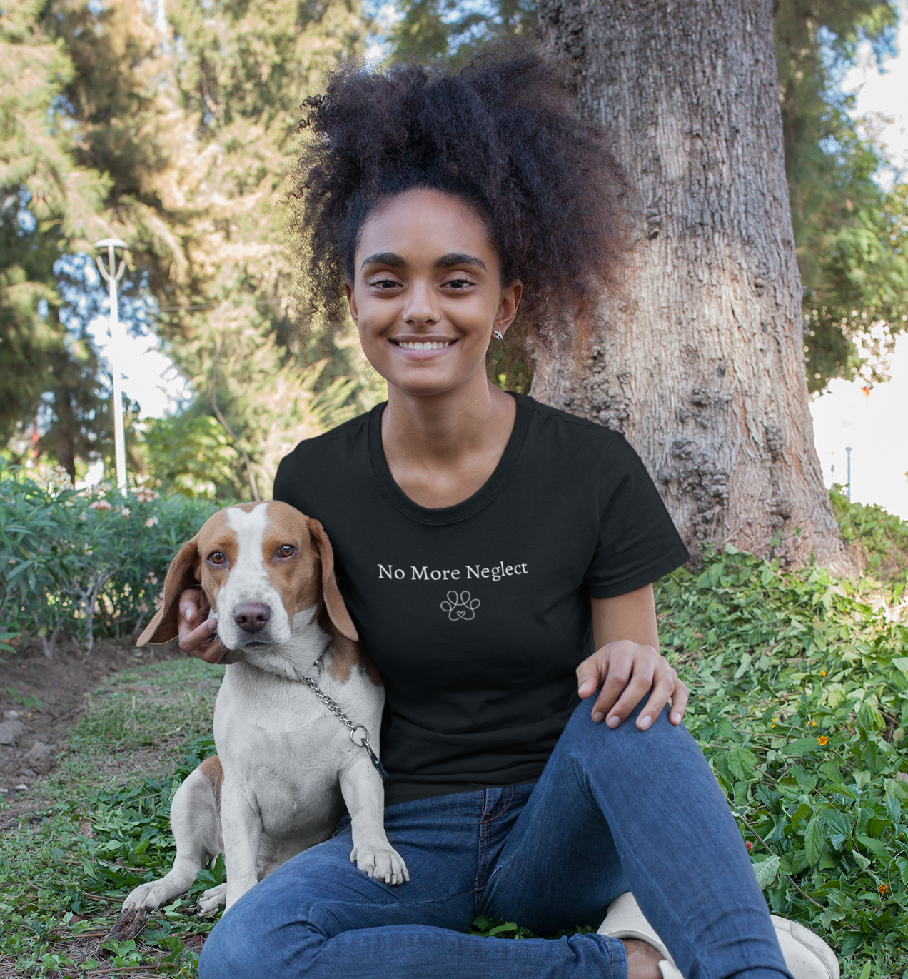 Woman sitting outdoors with a dog, wearing a black t-shirt with 'No More neger' text.
