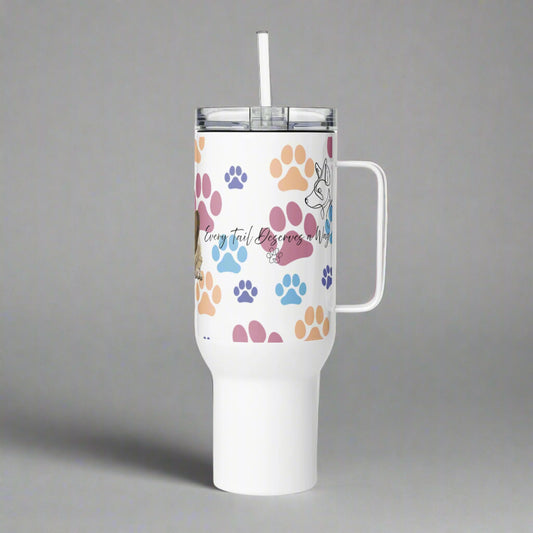 White tumbler with colorful paw prints and a handle on a gray background