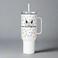 White tumbler with a handle and straw featuring paw prints and a dog graphic on a gray background